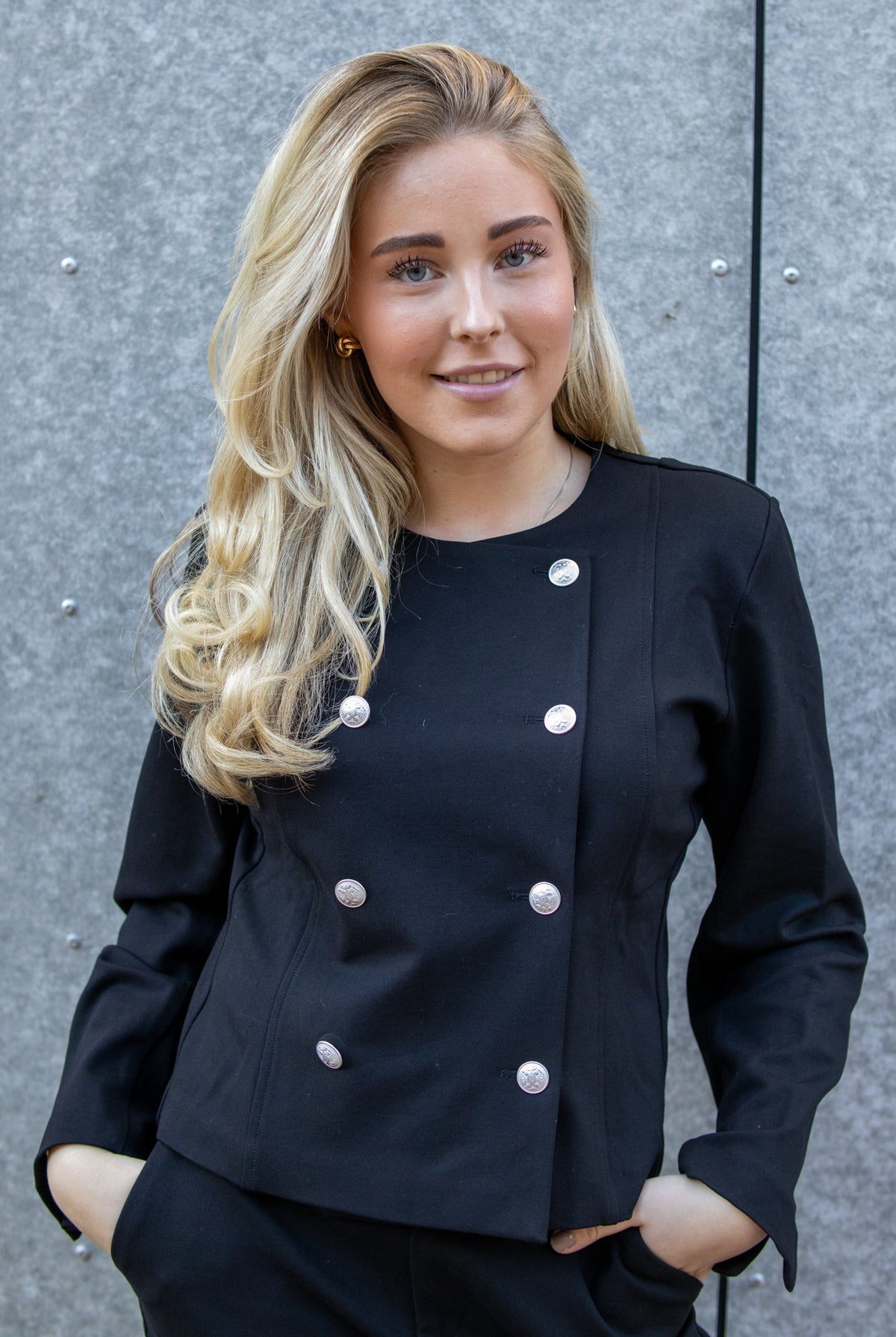Sort Ella Button Jacket fra Pieszak, en heltdilla av jakke med knapper og glatt svart stoff.