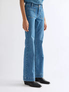Wrangler Flare Indigo Rush bukser med høyt liv og vidde ben, klassisk denimstil med blå vask og flatterende passform.
