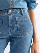 Wrangler Flare Indigo Rush bukser med høyt midje og vide ben, laget av denim med klassisk blåfarge og moderne passform.