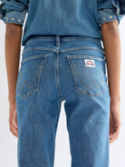 Wrangler Flare Indigo Rush bukser med høyt liv og klassisk denimfarge, vises med brede ben og forsterkede sømmer.